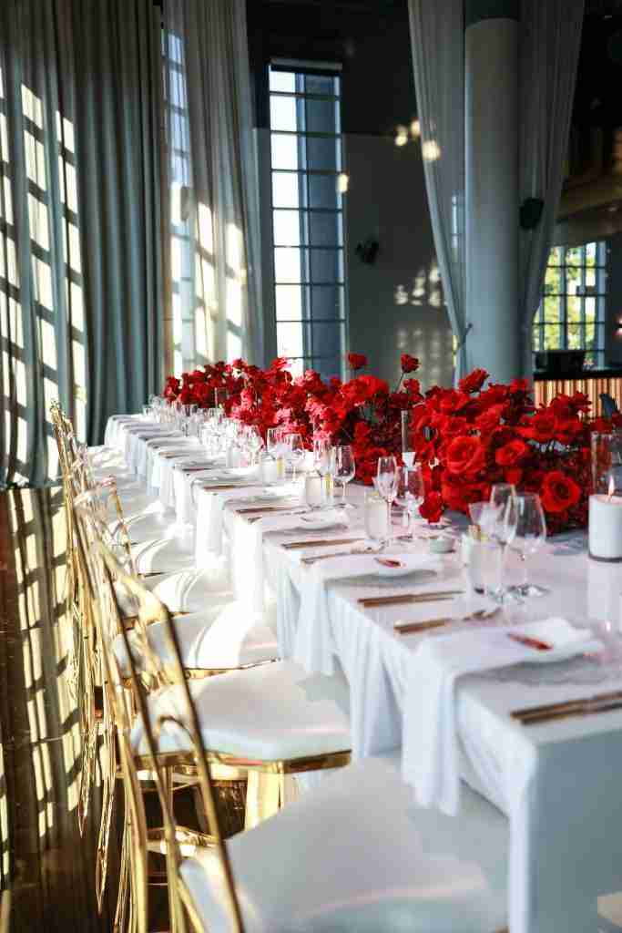 long wedding table with red flowers at metropolis events luxury wedding venue in southbank